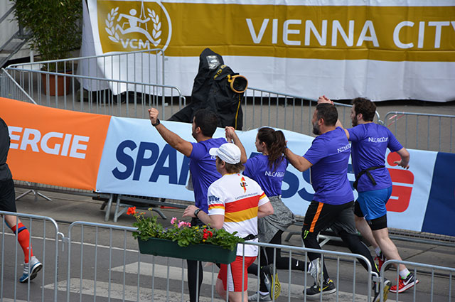 NILCARGO Läufer auf der Strecke vor dem Vienna City Marathon Banner