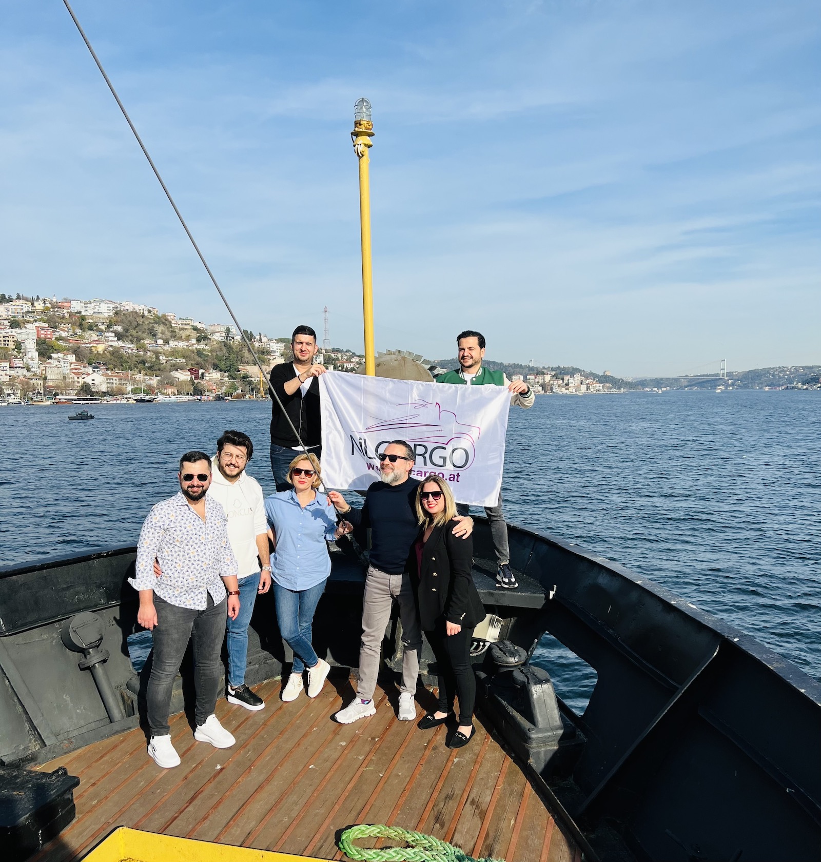 Das NILCARGO Team mit Flagge auf einem Boot am Bosporus